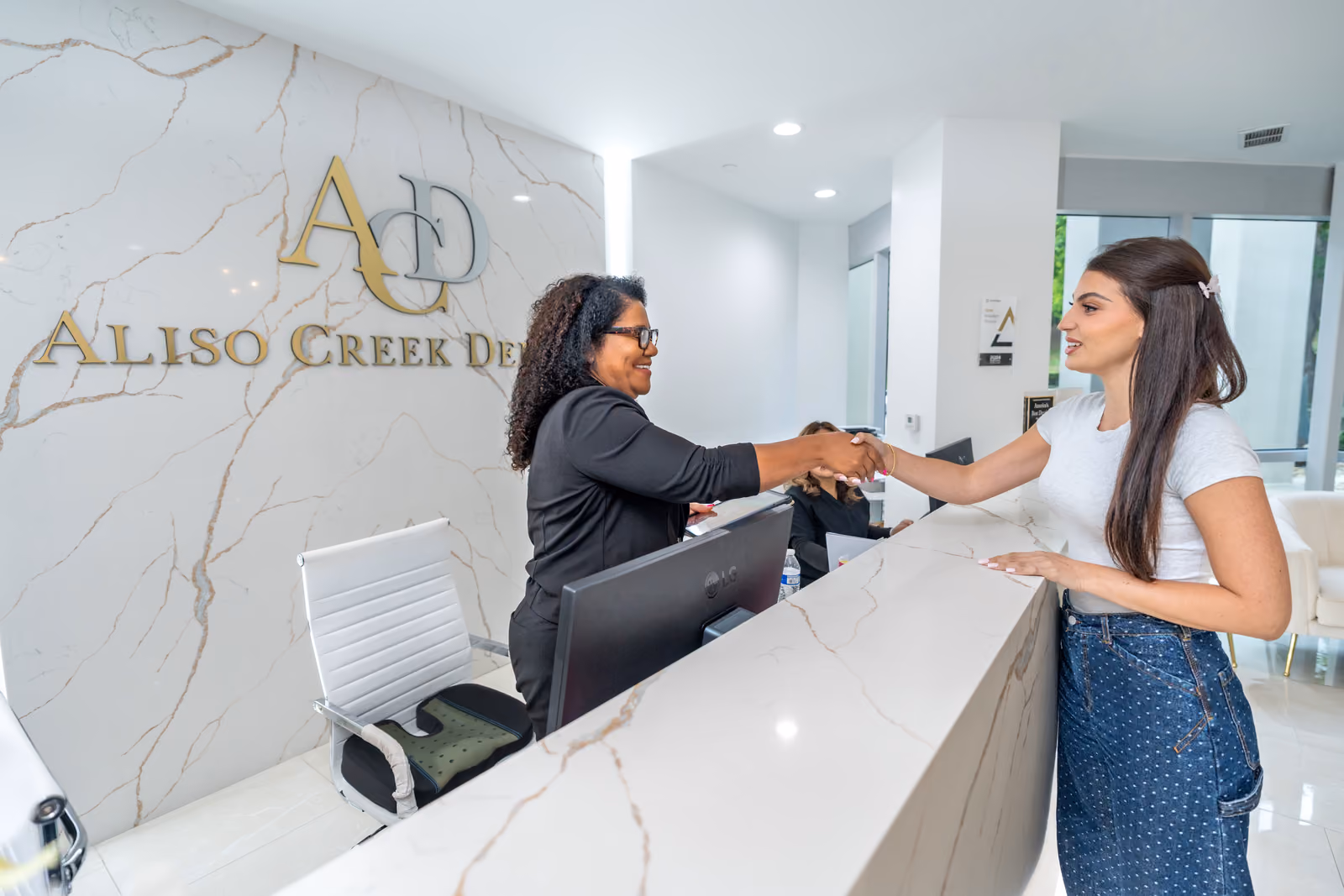 A patient is welcomed at the Aliso Creek Dental front desk.